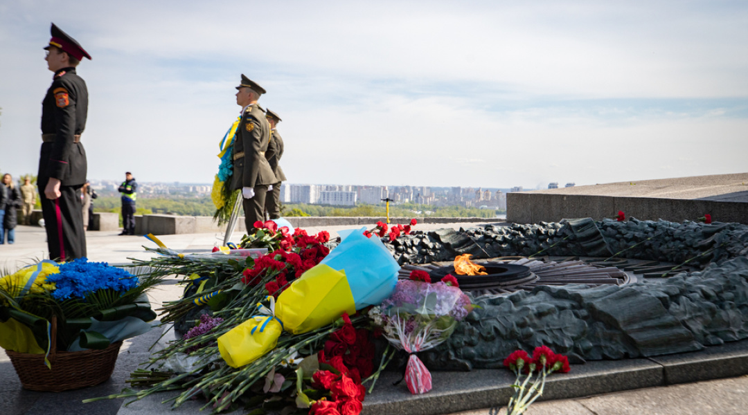 люди покладають квіти до меморіалу жертв війни