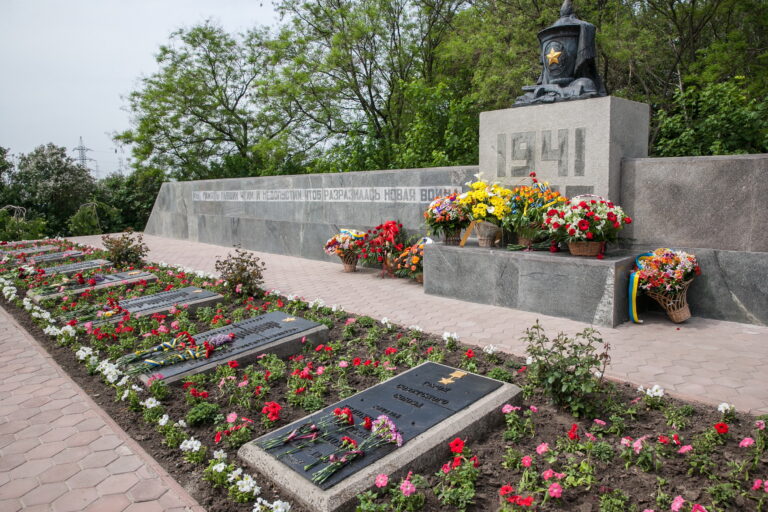 люди покладають квіти до меморіалу жертв війни